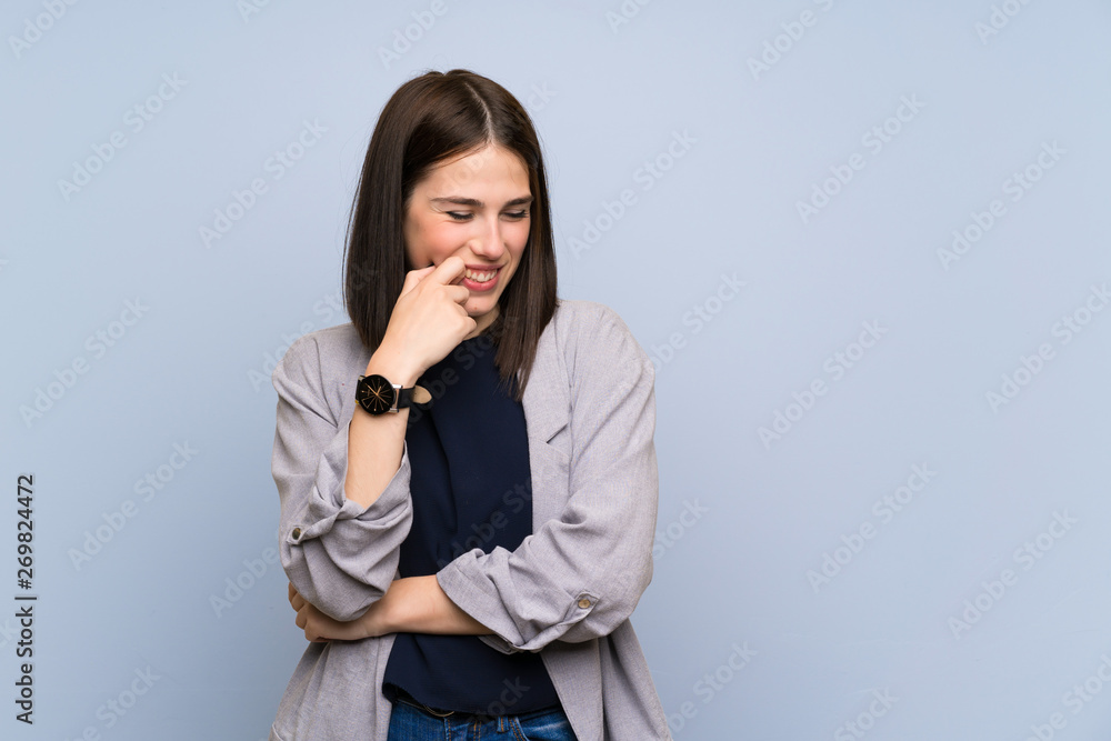 Young woman over isolated blue wall looking to the side Young woman over isolated blue wall looking to the side