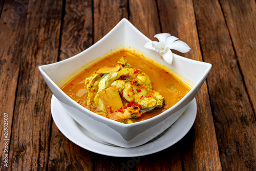 SEAFOOD - KAENG SOM PLA KAPONG : HOT AND SPICY DELICIOUS SEABASS IN YELLOW CURRY LOCAL THAI FOOD. photo