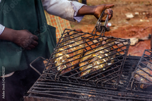 Photography Freshwater river tilapia fish grilled on a cast iron gridiron grill barbecue