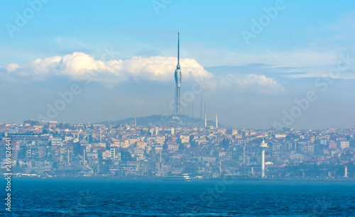 Evening view from the Bosphorus on Uskudar district, lighthouse and the Camlıca TRT Television Tower in the background. Istanbul, Turkey photo