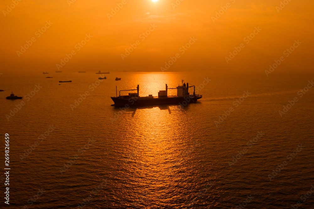 silhouette logistics shipping cargo open sea and over the sunset background