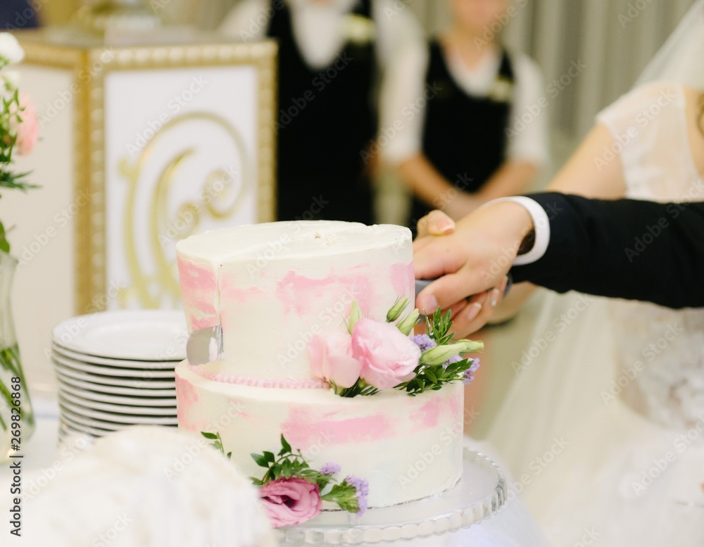 Bride and groom cut the wedding cake close up Bride and groom cut the wedding cake close up