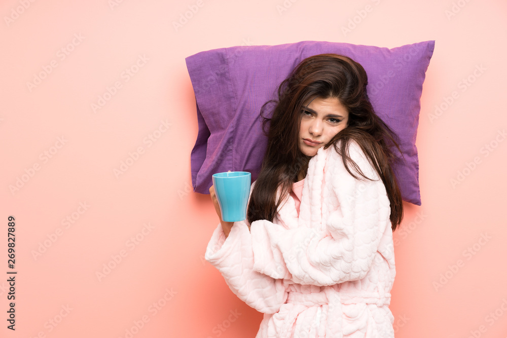 teenager girl in dressing gown over pink backgrounnd and holding a cup of coffee teenager girl in dressing gown over pink backgrounnd and holding a cup of coffee