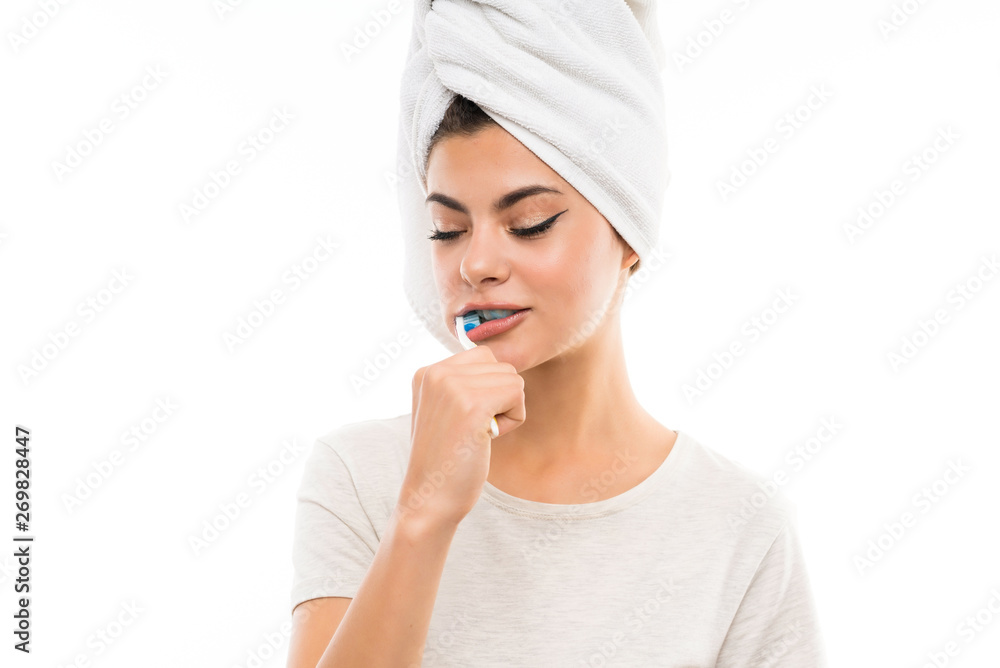 Teenager girl over isolated white background brushing her teeths Teenager girl over isolated white background brushing her teeths