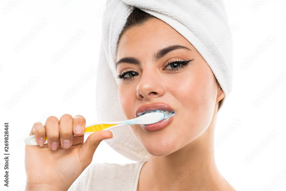 Teenager girl over isolated white background brushing her teeths Teenager girl over isolated white background brushing her teeths