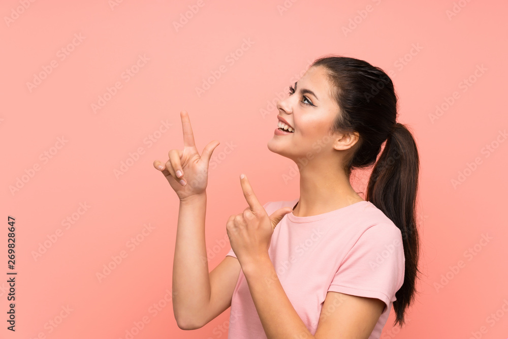 Teenager girl over isolated pink background pointing with the index finger a great idea Teenager girl over isolated pink background pointing with the index finger a great idea