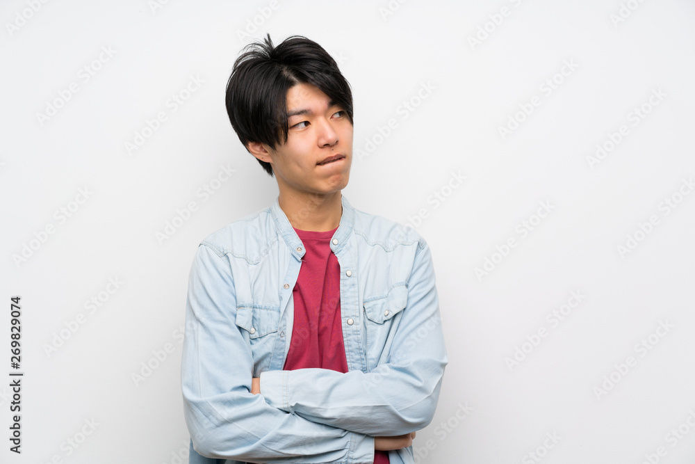 Asian man on isolated white background with confuse face expression Asian man on isolated white background with confuse face expression