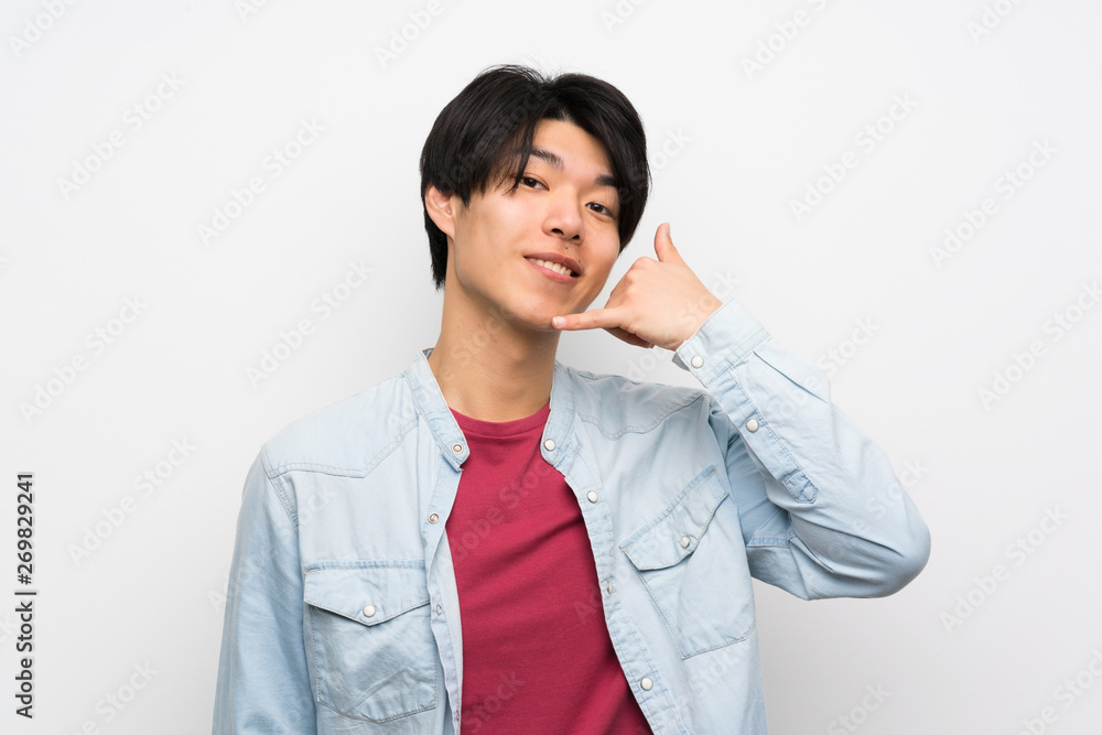 Asian man on isolated white background making phone gesture. Call me back sign Asian man on isolated white background making phone gesture. Call me back sign