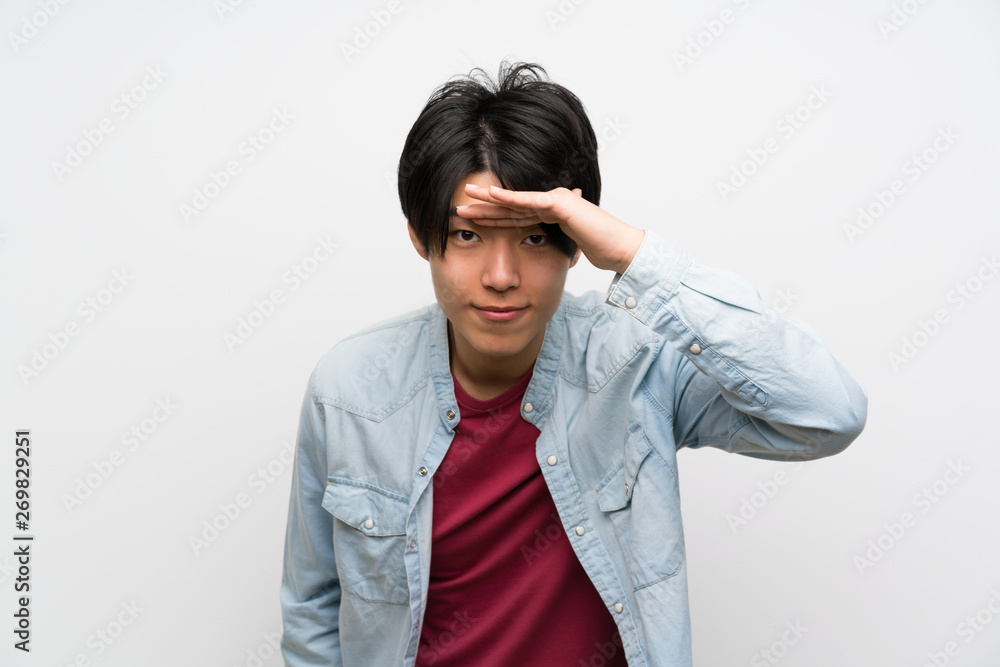 Asian man on isolated white background looking far away with hand to look something Asian man on isolated white background looking far away with hand to look something
