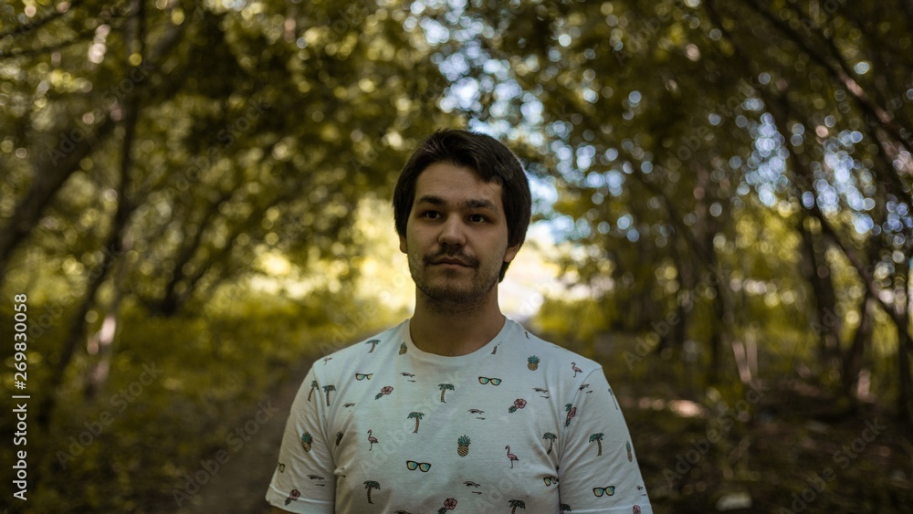 the man looks up and a white t-shirt on a background of yellow forest the man looks up and a white t-shirt on a background of yellow forest
