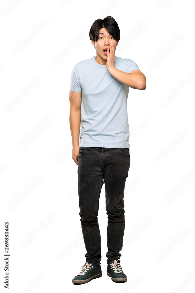 A full-length shot of a Asian man with blue shirt with surprise and shocked facial expression over isolated white background A full-length shot of a Asian man with blue shirt with surprise and shocked facial expression over isolated white background