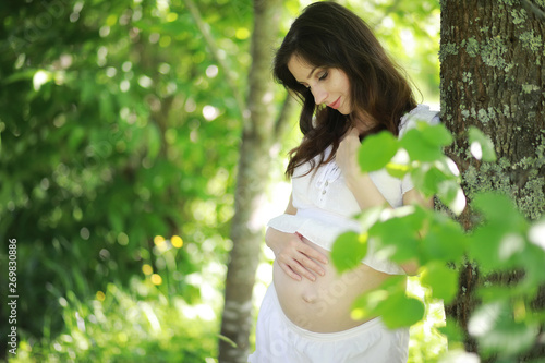 Pregnant woman in nature for a walk summer