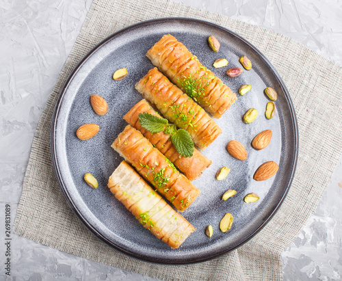 Baklava, traditional arabic sweets in gray ceramic plate on a gray concrete background. top view. photo