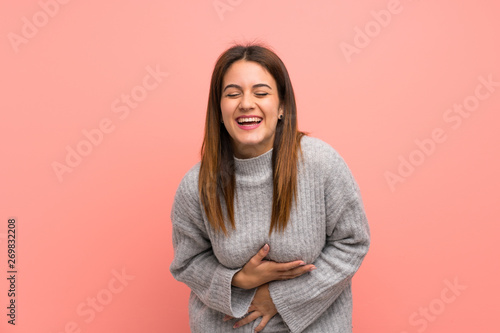 Young woman over pink wall smiling a lot © luismolinero