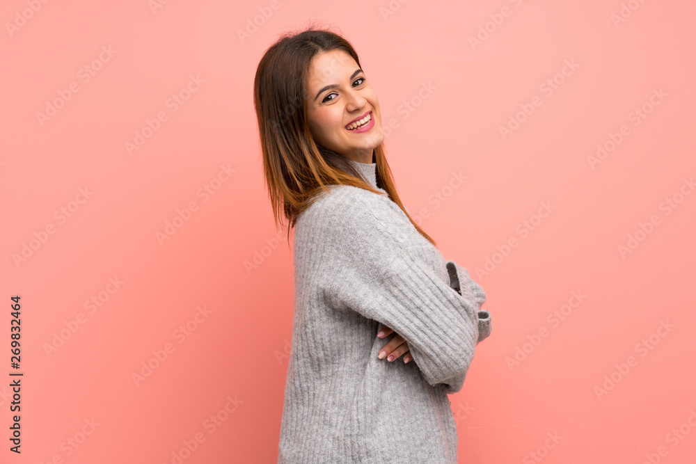 Young woman over pink wall with arms crossed and happy Young woman over pink wall with arms crossed and happy