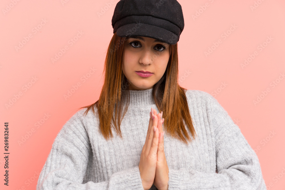 Fashion woman with hat over pink wall pleading