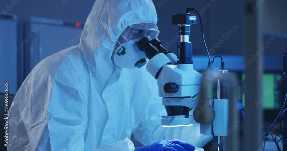Scientist examining sample with a microscope Scientist examining sample with a microscope