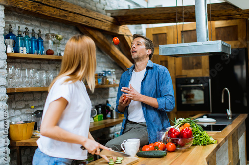 Lovely cheerful couple cook...