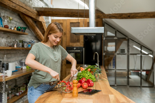 Happy young woman cooking d...