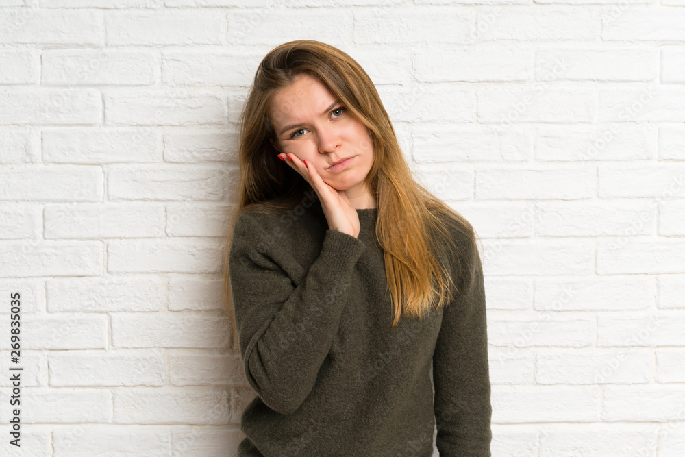 Young woman over white brick wall unhappy and frustrated Young woman over white brick wall unhappy and frustrated