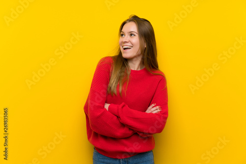 Young woman over yellow wall happy and smiling