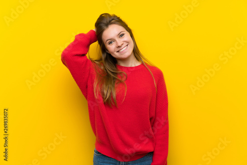 Young woman over yellow wall thinking an idea