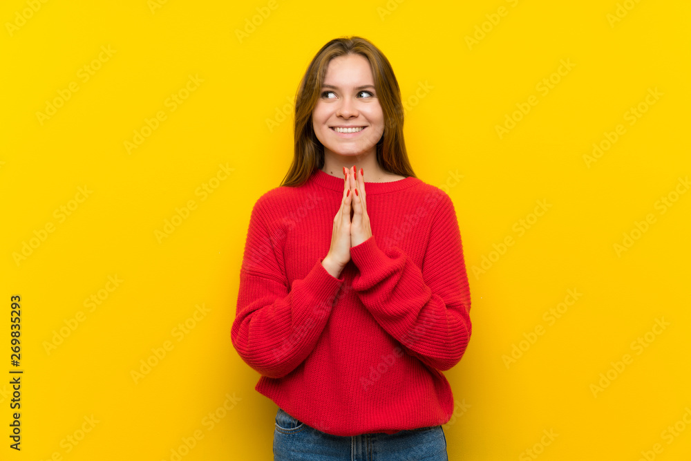 Young woman over yellow wall scheming something Young woman over yellow wall scheming something