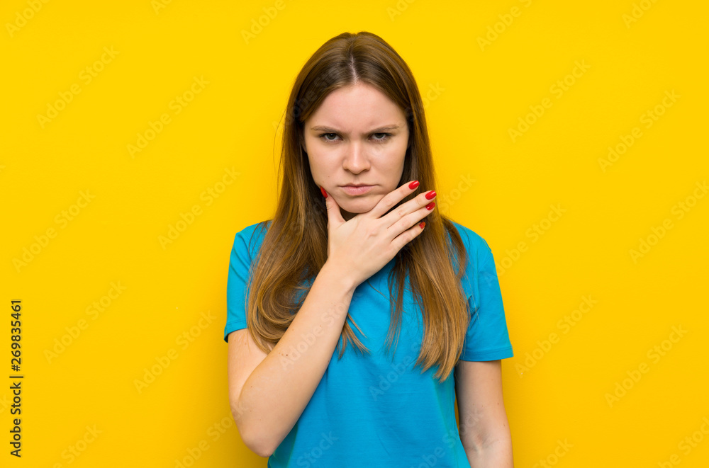 Young woman with blue shirt standing and thinking an idea Young woman with blue shirt standing and thinking an idea