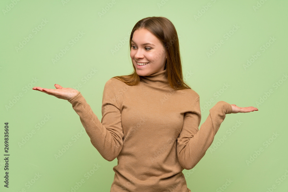 Young woman with turtleneck sweater holding copyspace with two hands Young woman with turtleneck sweater holding copyspace with two hands