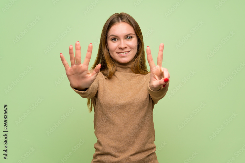 Young woman with turtleneck sweater counting seven with fingers Young woman with turtleneck sweater counting seven with fingers
