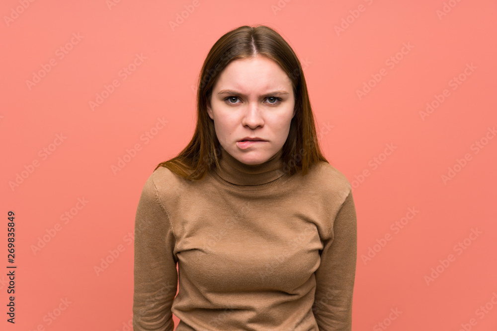 Obraz premium Young woman over colorful background having doubts and with confuse face expression
