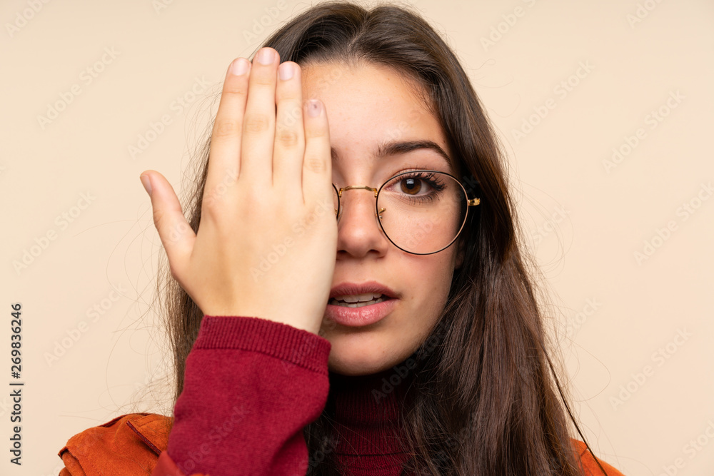 Teenager girl with coat covering a eye by hand Teenager girl with coat covering a eye by hand
