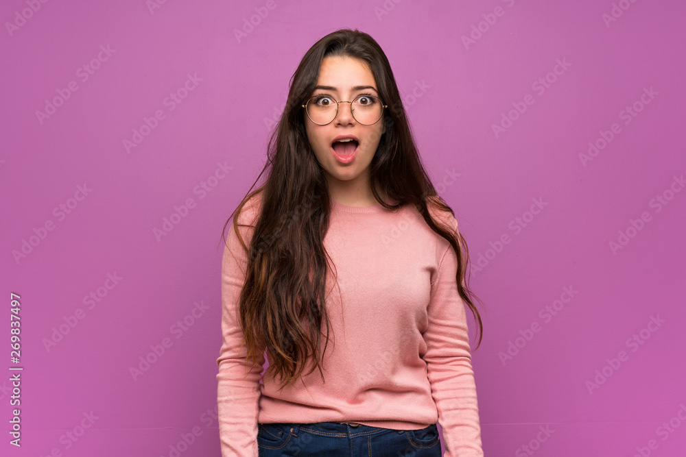 Teenager girl over purple wall with surprise facial expression Teenager girl over purple wall with surprise facial expression