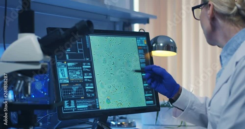 Scientist using a microscope in a lab photo