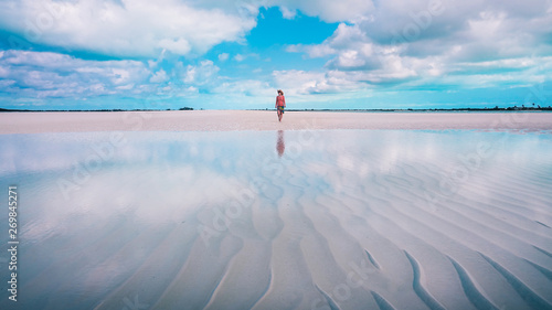 Woman walking on the sandbar at the Exumas, the Bahamas.