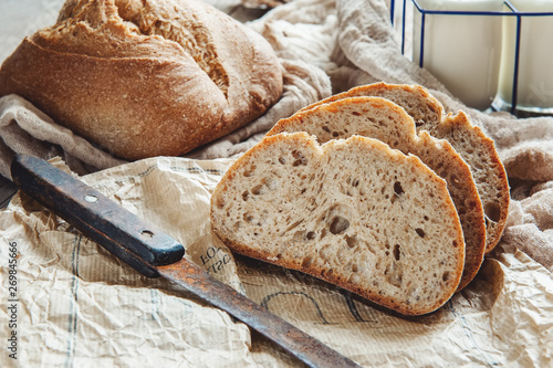 Fényképezés A beautiful loaf of sourdough bread from white wheat on a plate on a linen edge