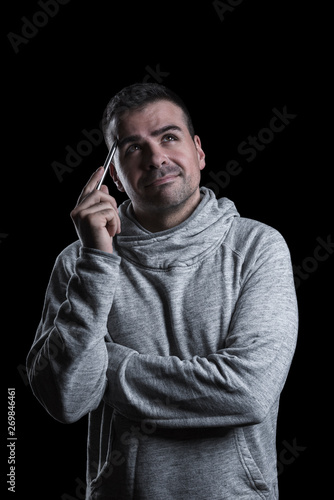 Studio portrait of a man thinking and looking up. Isolated on black background. Vertical.