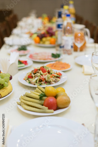 Laid table with vegetables, salads.