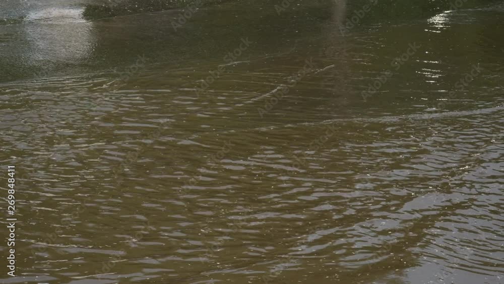 city road after a rainstorm. Water from under the wheels of a car. reflection of passing cars in a puddle city road after a rainstorm. Water from under the wheels of a car. reflection of passing cars in a puddle