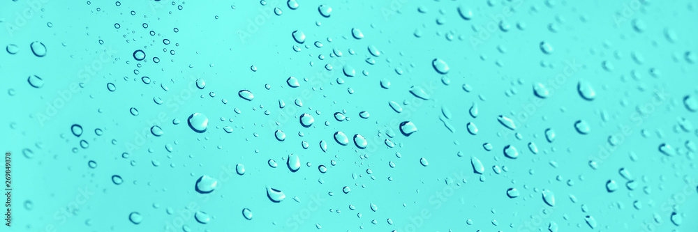 Water drops on glass panoramic blue background Water drops on glass panoramic blue background