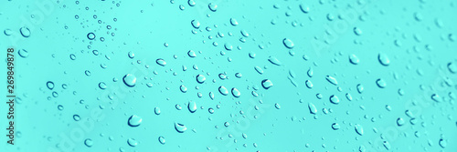 Water drops on glass panoramic blue background