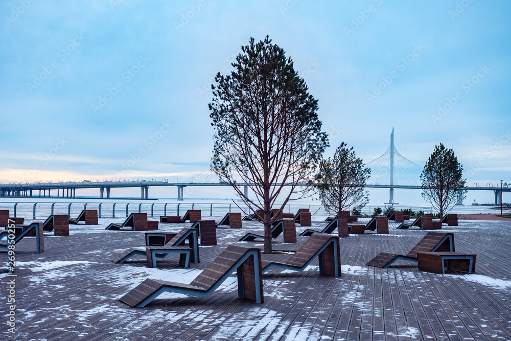 St. Petersburg. Russia. Quay Krestovsky island recreation location in winter. Relaxation area with sunbeds overlooking the Gulf of Finland. Embankments of St. Petersburg. Russian cities.
