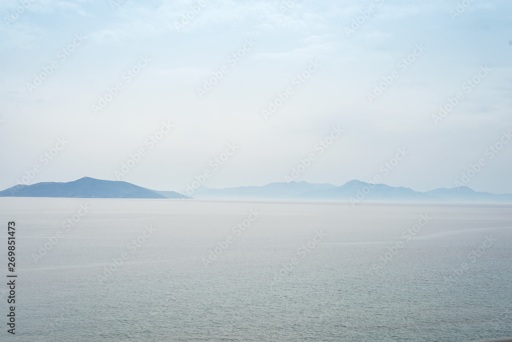 Beautiful mysterious nature background with of the ocean against the misty mountains Beautiful mysterious nature background with of the ocean against the misty mountains