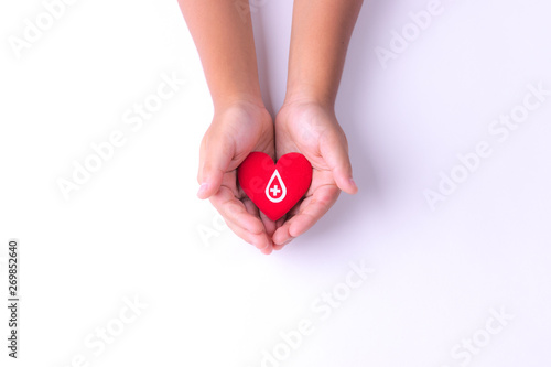 A child hands holding red heart for blood donation,world blood donor day. Copy space for advertisers.