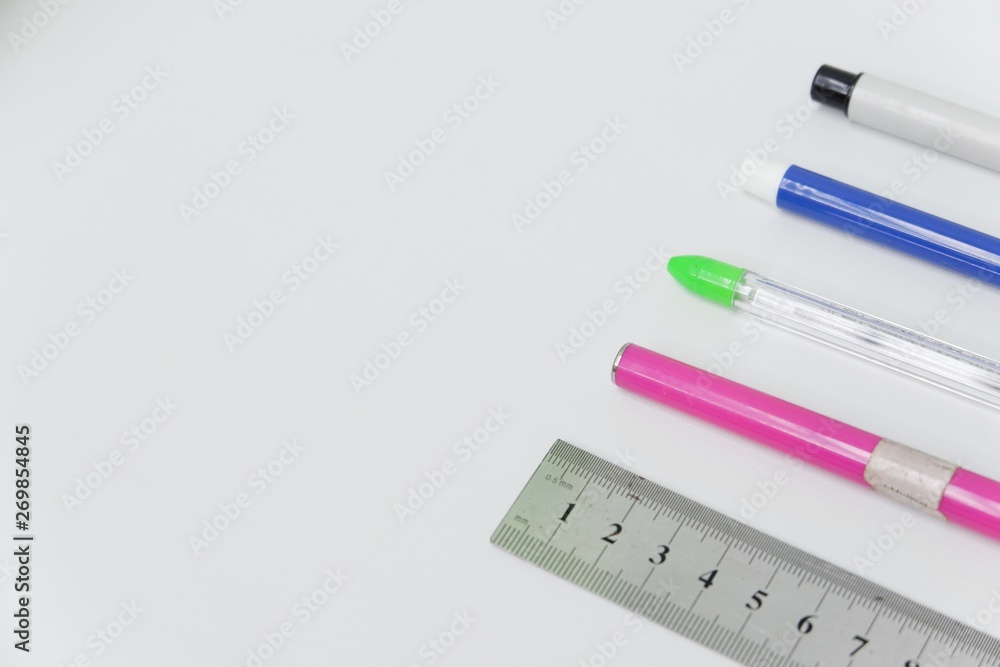 Pens and ruler on white background. Top view close up details. Pens and ruler on white background. Top view close up details.