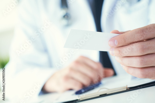 Wallpaper Mural Male physician hand holding and giving white blank calling card closeup in office. Contact information exchange, introducing gesture at formal meeting, personal or family doctor concept Torontodigital.ca