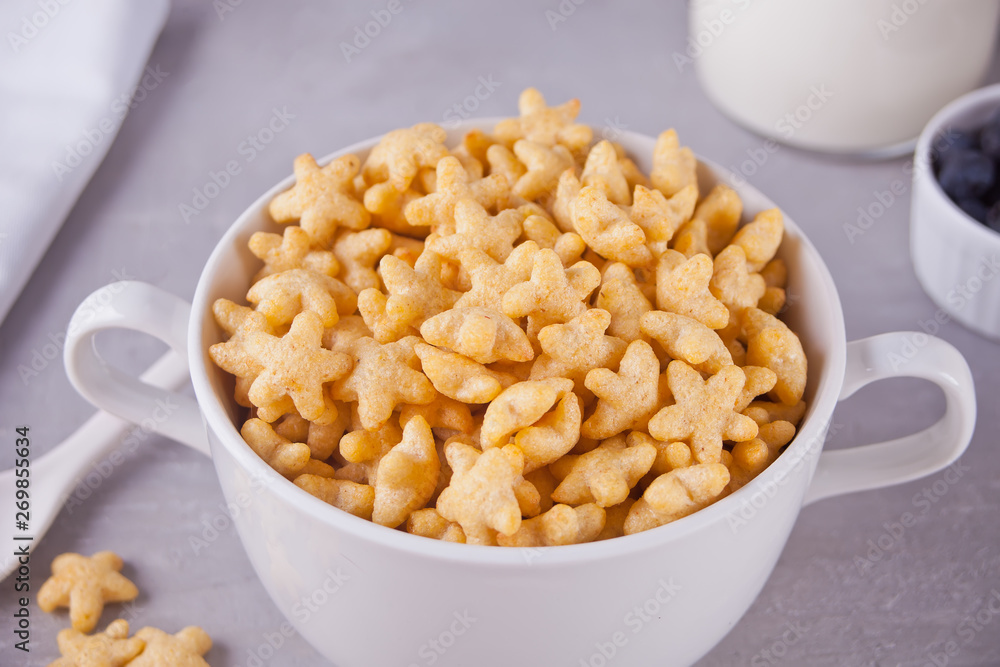 A bowl of dry star shaped cereal on gray background A bowl of dry star shaped cereal on gray background