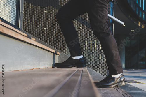 Businessman legs walking up the stairs