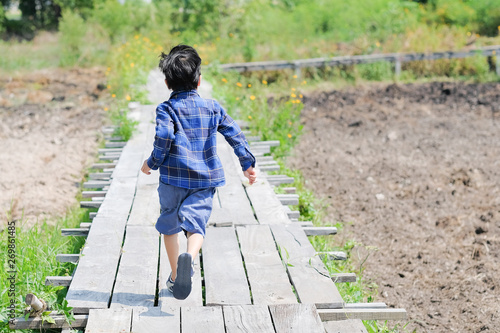 The boy is running forward.