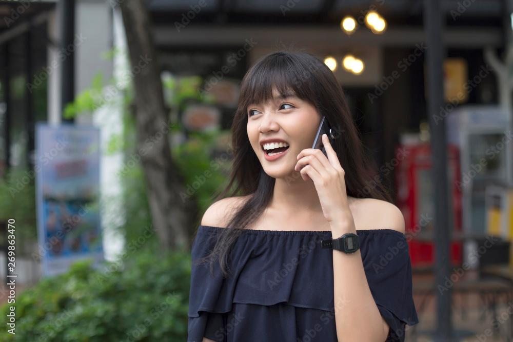 smiling young asian woman talking on smart phone smiling young asian woman talking on smart phone